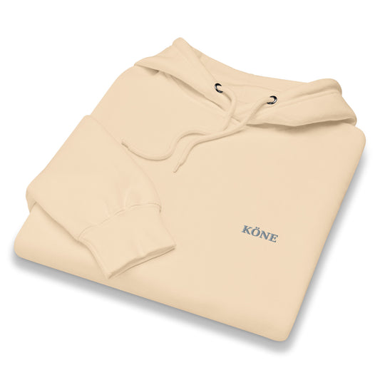 Sudadera KONE beige doblada mostrando logo bordado en el pecho.