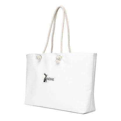 Detalle del logo KÖNE en la bolsa Weekender blanca con asas de cuerda beige.