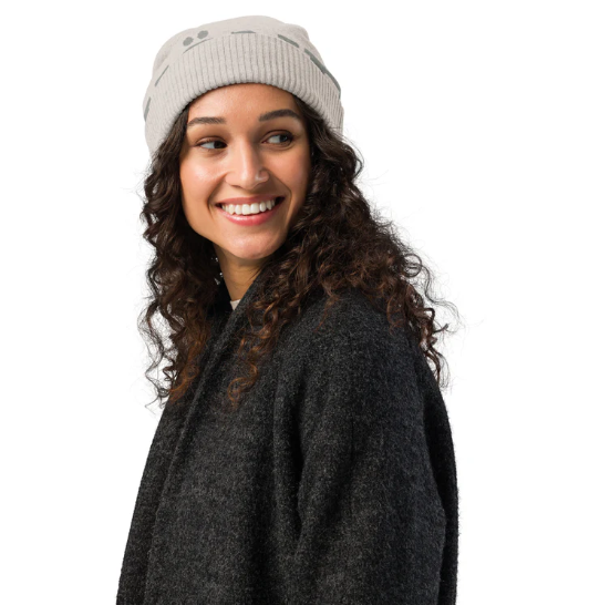 Mujer con gorro KÖNE beige y abrigo gris, estilo casual elegante en ambiente urbano.