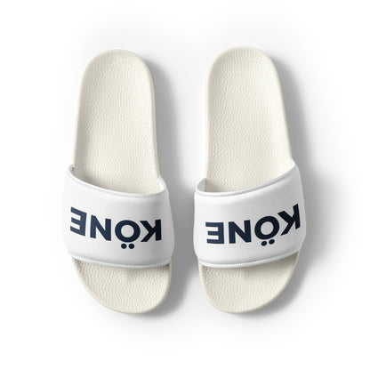 Sandalias KÖNE blancas con tira acolchada y logo negro, diseño ligero y ergonómico.