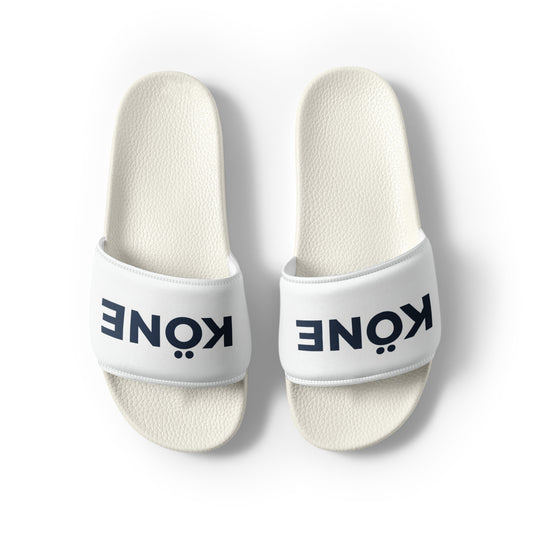 Sandalias KÖNE blancas con tira acolchada y logo negro, diseño ligero y ergonómico.