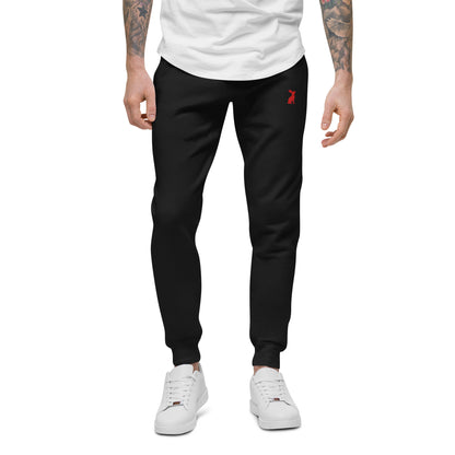 Modelo masculino con pantalón KÖNE negro unisex y camiseta beige, corte recto y cómodo.