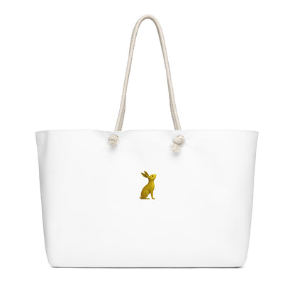 Bolsa KÖNE Weekender color blanco con logotipo dorado vista frontal, asas de cuerda natural y fondo neutro.