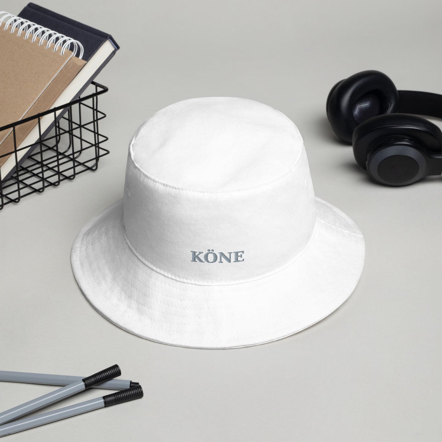 Gorro bucket KÖNE blanco estilo minimalista sobre un escritorio