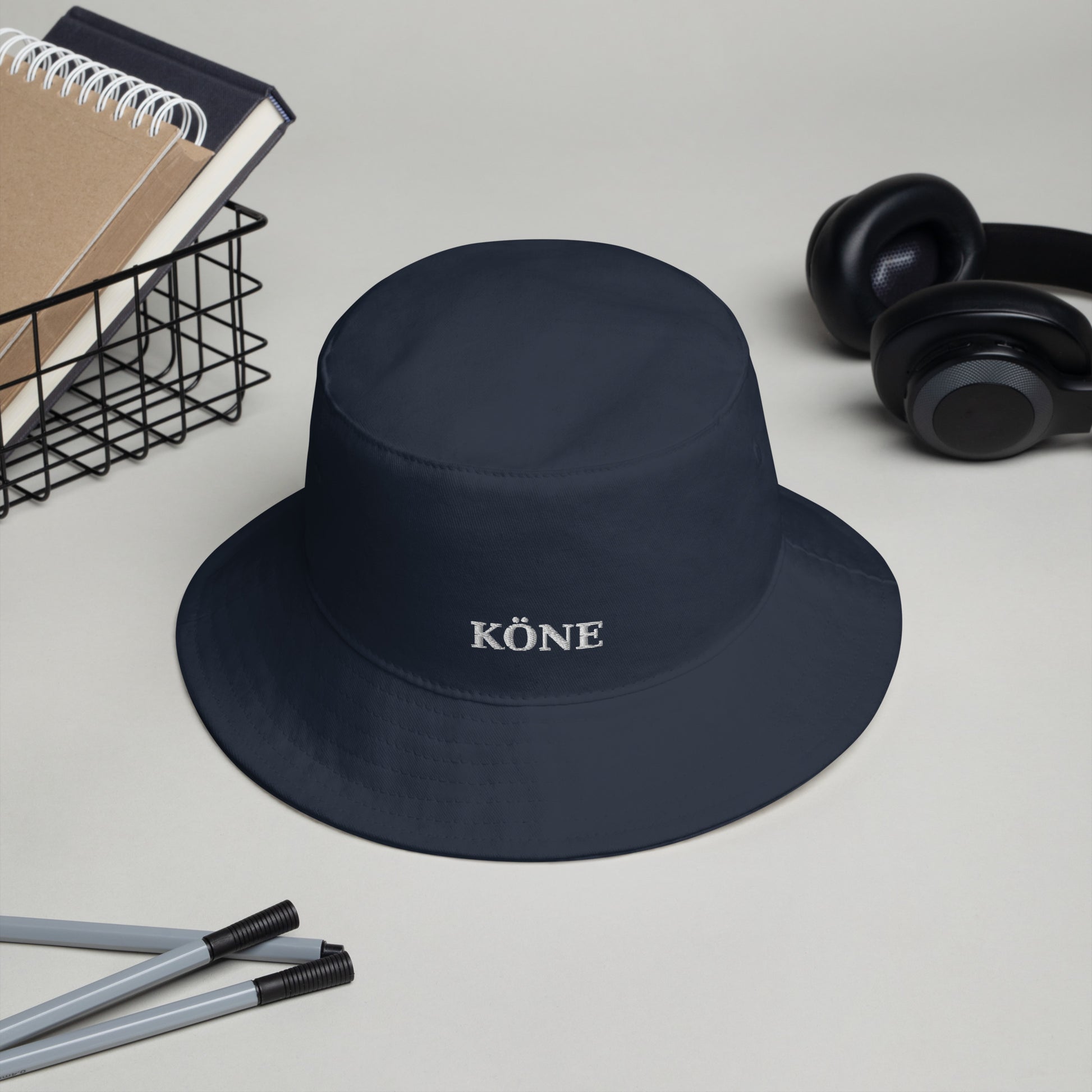 Gorro bucket KÖNE marino unisex sobre un escritorio